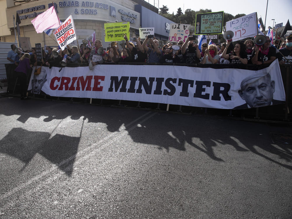 Protesters gather outside the District Court in Jerusalem where Prime Minister Benjamin Netanyahu was attending his corruption trial Monday.