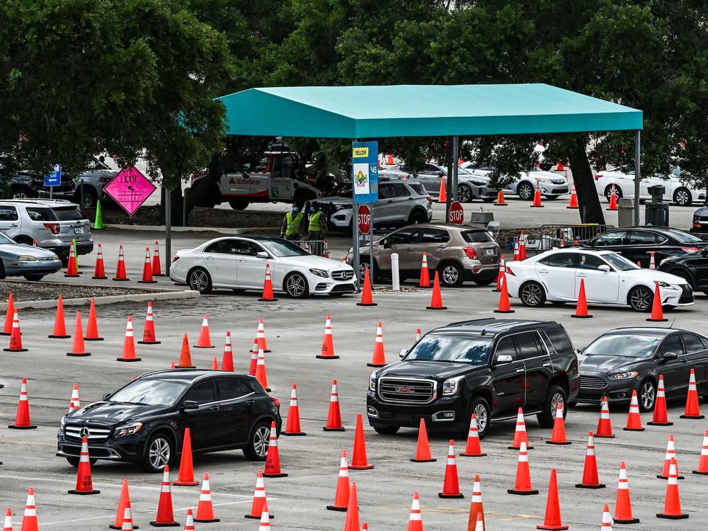 People wait in their vehicles to get vaccinated last week at a drive-through site at Hard Rock Stadium in Miami Gardens, Fla. President Biden announced an April 19 deadline for all states to open eligibility to individuals ages 18 and up.
