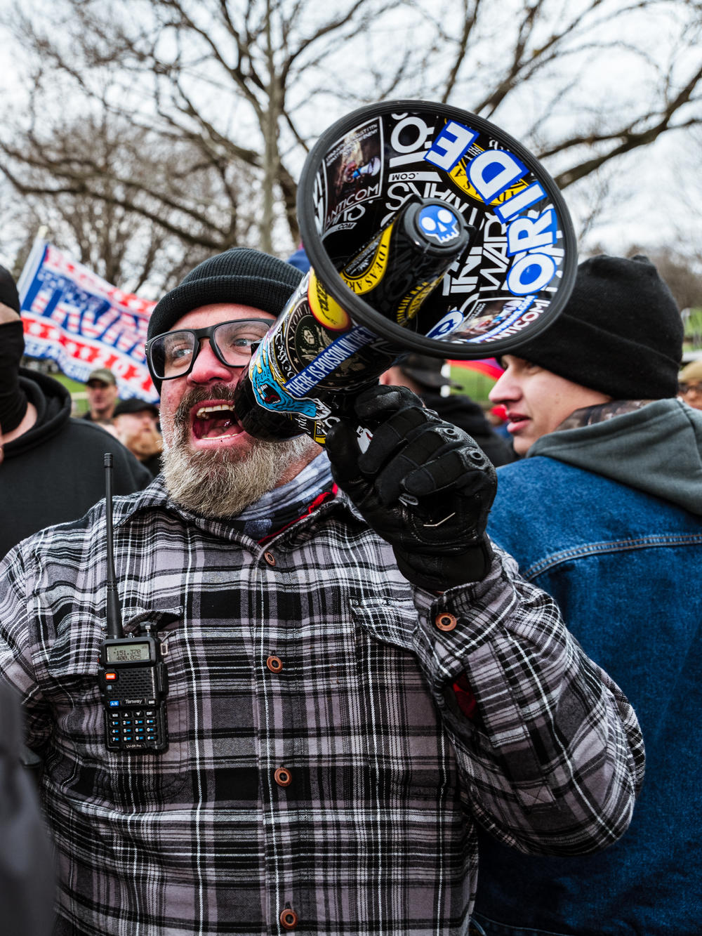 Joe Biggs, a member of the Proud Boys, speaks into a megaphone in front of the U.S. Capitol on Jan. 6. Biggs, charged in the Capitol riot, assisted in the group's growth and also has a history of violent rhetoric.