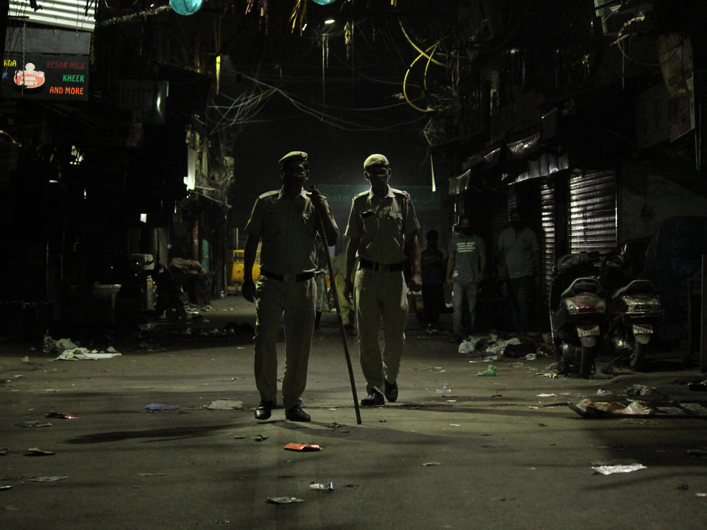 Police officers stand guard during a night curfew designed to limit the spread of the coronavirus in New Delhi. The national capital has imposed a 10 p.m. to 5 a.m. curfew until April 30.