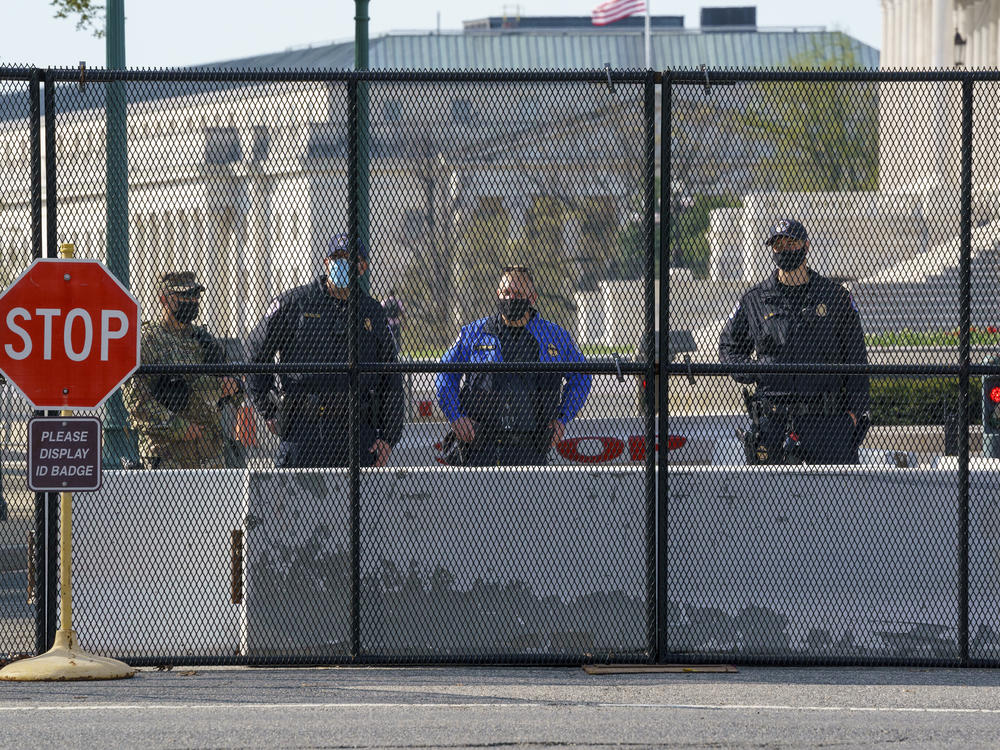 U.S. Capitol Police officers and members of the National Guard keep watch at the Constitution Avenue entrance to the East Plaza of the Capitol where an officer was killed when a man rammed a car into the barricade on April 2. The debate about whether there should be permanent fencing will be front and center when lawmakers return next week.