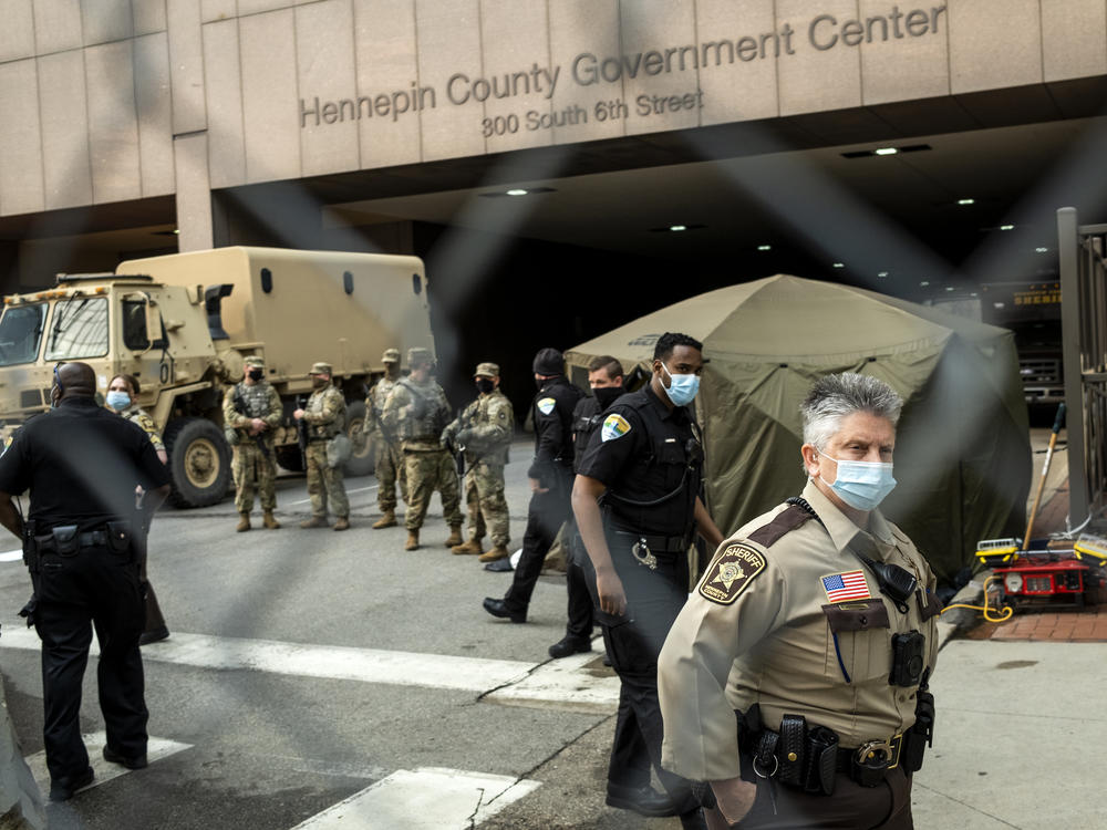 Jurors are escorted into the Hennepin County Government Center by sheriff's deputies. Here, members of the Minnesota National Guard and other agencies stand watch outside the building in Minneapolis.