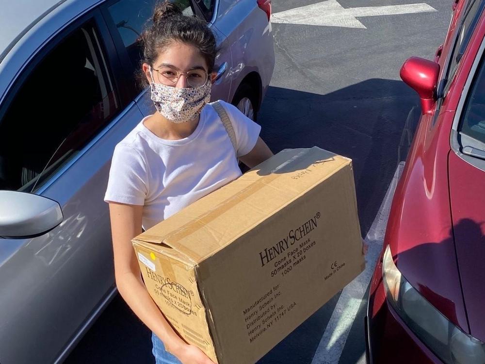 Ramah Awad, community organizer at Majdal center in San Diego County, Calif., carrying a box of PPE.
