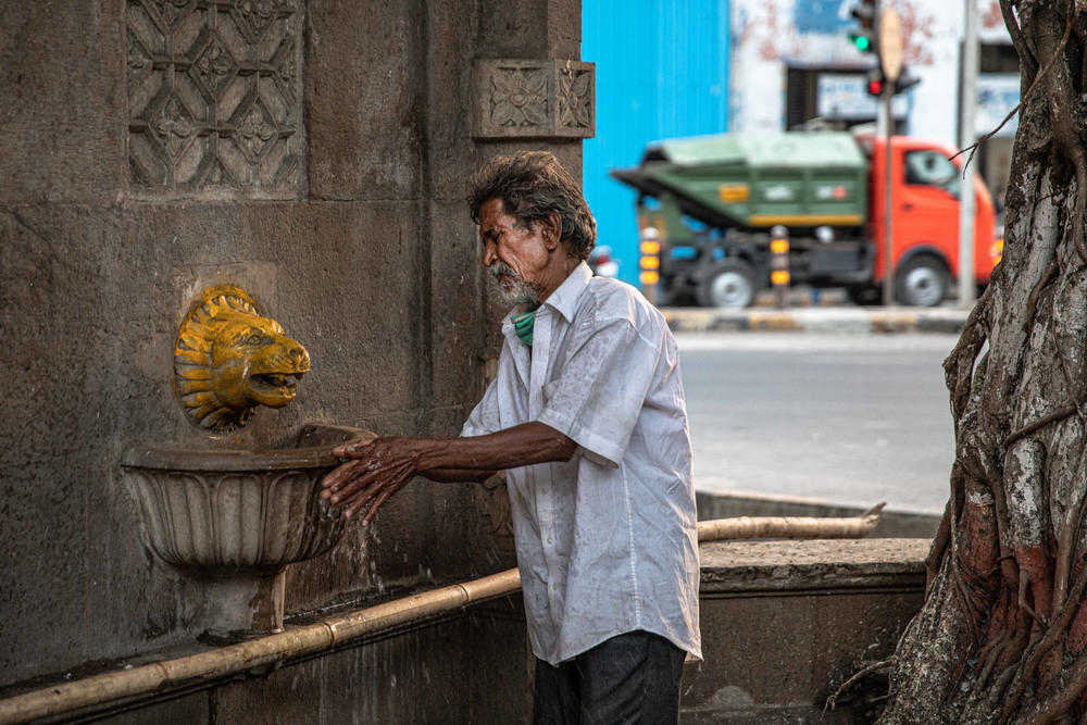 A man washes his hands at one of Mumbai's public fountains. Frequent hand-washing is a key defense during the coronavirus pandemic, but it's not practical advice for lower-income families in Mumbai who live with severe water uncertainty.