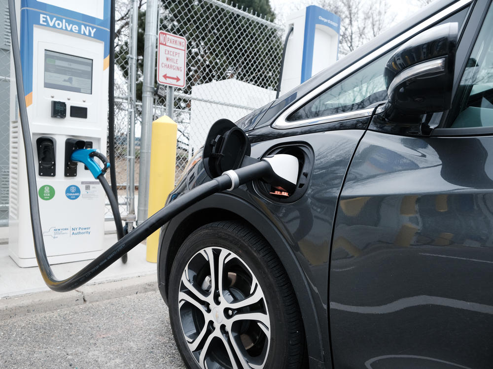 A driver uses a fast-charging station for electric vehicles at New York's John F. Kennedy Airport on April 2. As part of President Biden's $2 trillion infrastructure plan, $174 billion would go to supporting the production of electric vehicles in the U.S.