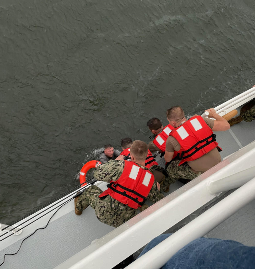 The crew of the Coast Guard Cutter Glenn Harris pulls a person from the water that was on the overturned commercial vessel off the coast of Louisiana.