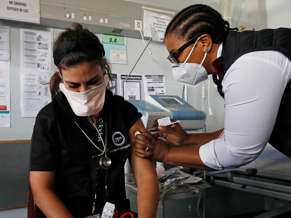 Dr. Anike Baptiste receives a dose of J&J from nurse Mokgadi Malebye at a Pretoria hospital last February. South Africa is one of the countries that announced a pause on the J&J vaccine while more research is done into potential blood clots that occurred in younger women after getting the vaccine.