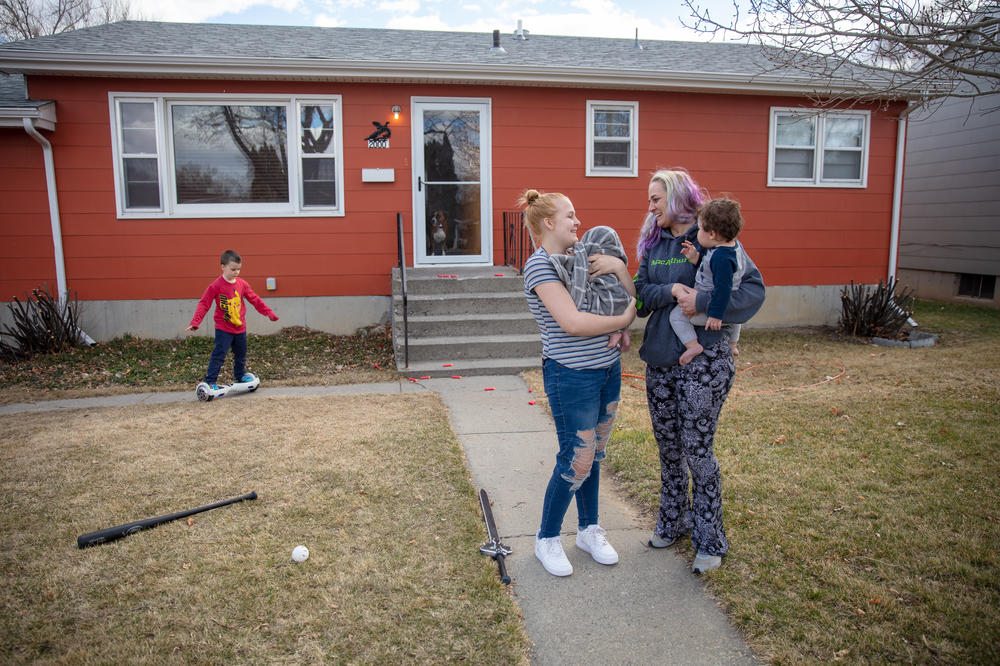 Gaught (right) holds her 9-month-old grandson, Adonis, while her daughter Trinity, 16, holds her newborn baby at the home they now rent in Billings, Mont. Gaught's 5-year-old son, Blazen, plays in the background. She says out of all of them, Blazen has been most upset about losing the house. 
