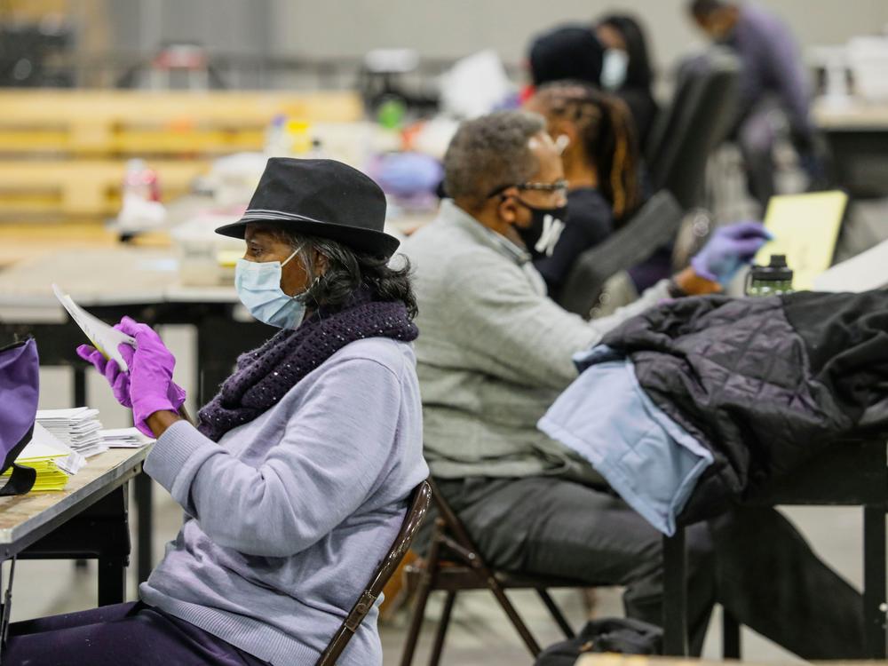 Atlanta election workers scan ballots and check for discrepancies earlier this year for Georgia U.S. Senate races. The state's controversial new voting law contains many changes for election officials.