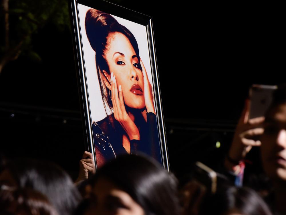 Fans with a photo of Selena during a ceremony honoring her in 2017. Over the decades since her death, Selena's legacy has become even more profound than writer Deborah Paredez ever anticipated.