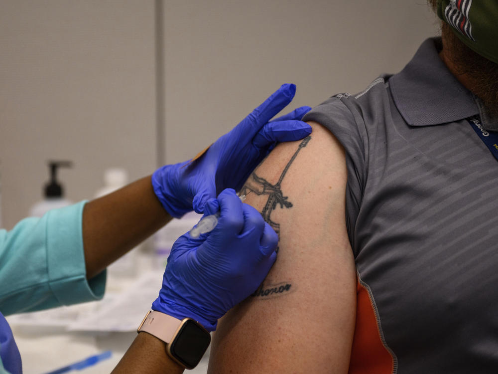 A Georgia Tech employee receives a Pfizer coronavirus vaccination on the campus April 8. For a number of Americans, getting their shots is as easy as showing up to their workplace as some companies and institutions provide on-site vaccinations to their employees.