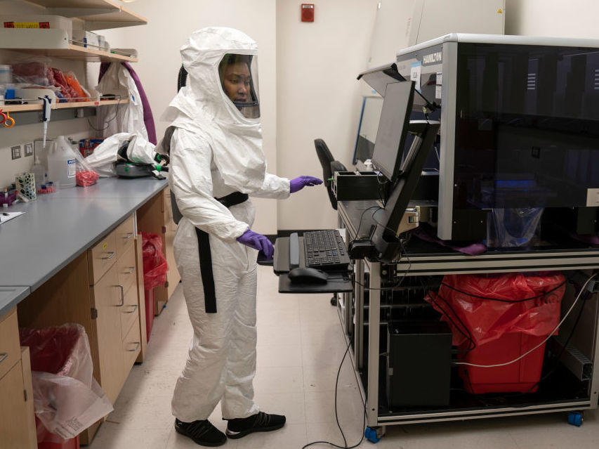 Lab assistant Tammy Brown dons personal protective equipment in a lab at the University of Maryland School of Medicine in Baltimore. She works on preparing positive coronavirus tests for sequencing to discern variants rapidly spreading throughout the country.