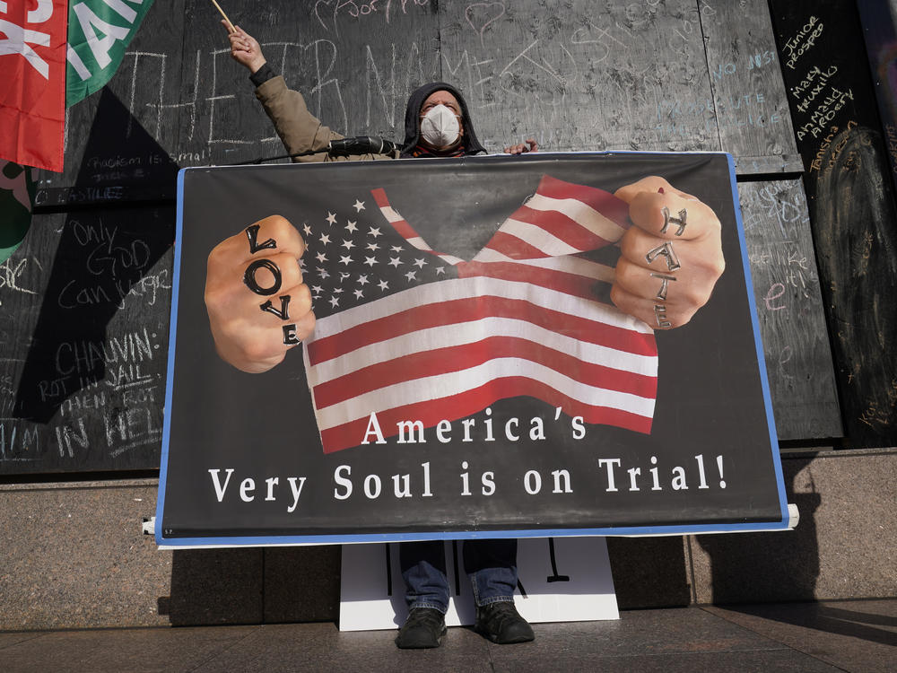 A protester stands across the street from the Hennepin County Government Center on Tuesday, where former Minneapolis police officer Derek Chauvin stands trial for the death of George Floyd.