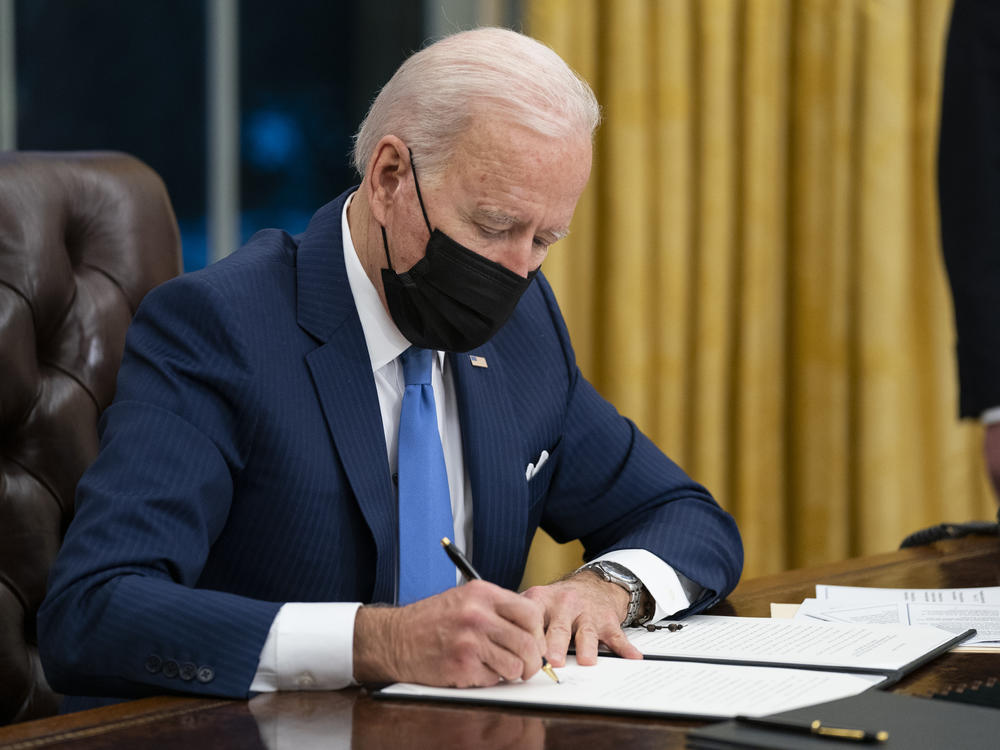President Biden signs an executive order on immigration in February in the Oval Office.