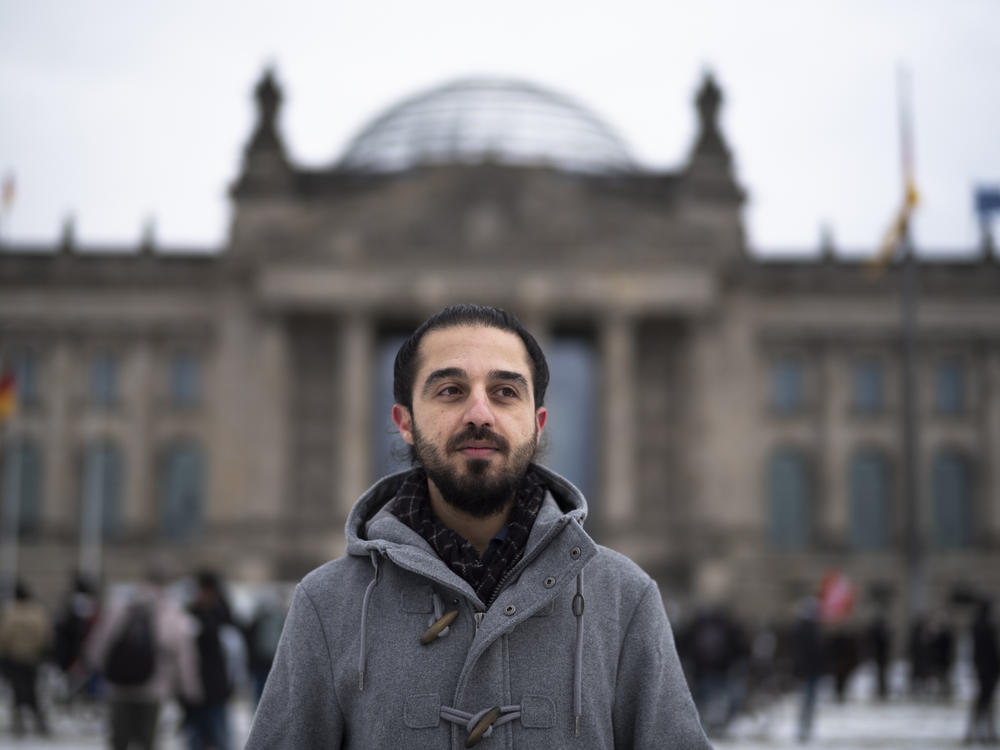 Tareq Alaows stands in front of the Bundestag, Germany's parliament, in Berlin. Alaows came to Germany as an asylum-seeker from Syria in 2015. He launched a campaign to run in Germany's federal election in September for the Green Party but recently withdrew his candidacy.