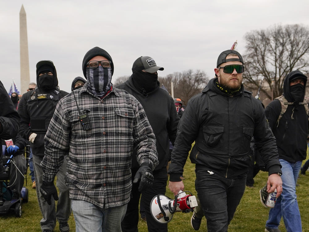 Proud Boy members Joseph Biggs (left) and Ethan Nordean, carrying a megaphone, walk toward the U.S. Capitol on Jan. 6. A federal judge ordered them detained pending trial given the conspiracy charges against them.