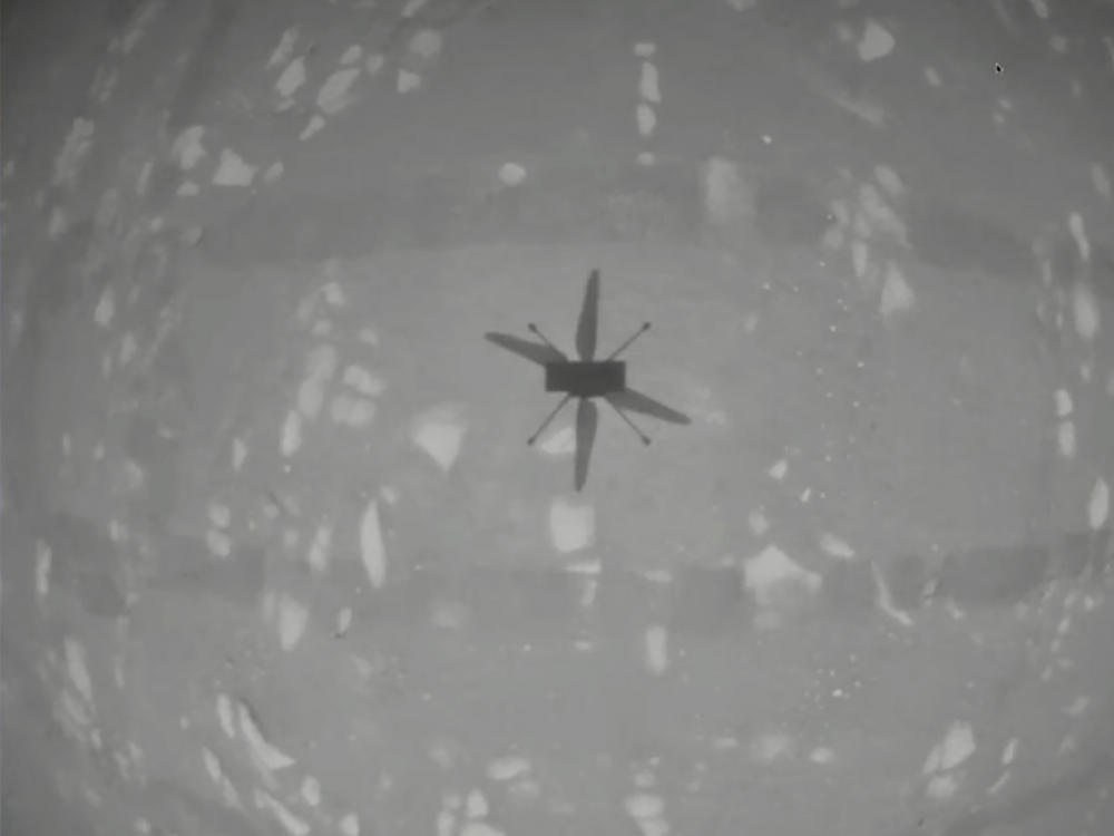 NASA's experimental Mars helicopter Ingenuity hovers above the surface of Mars on Monday.