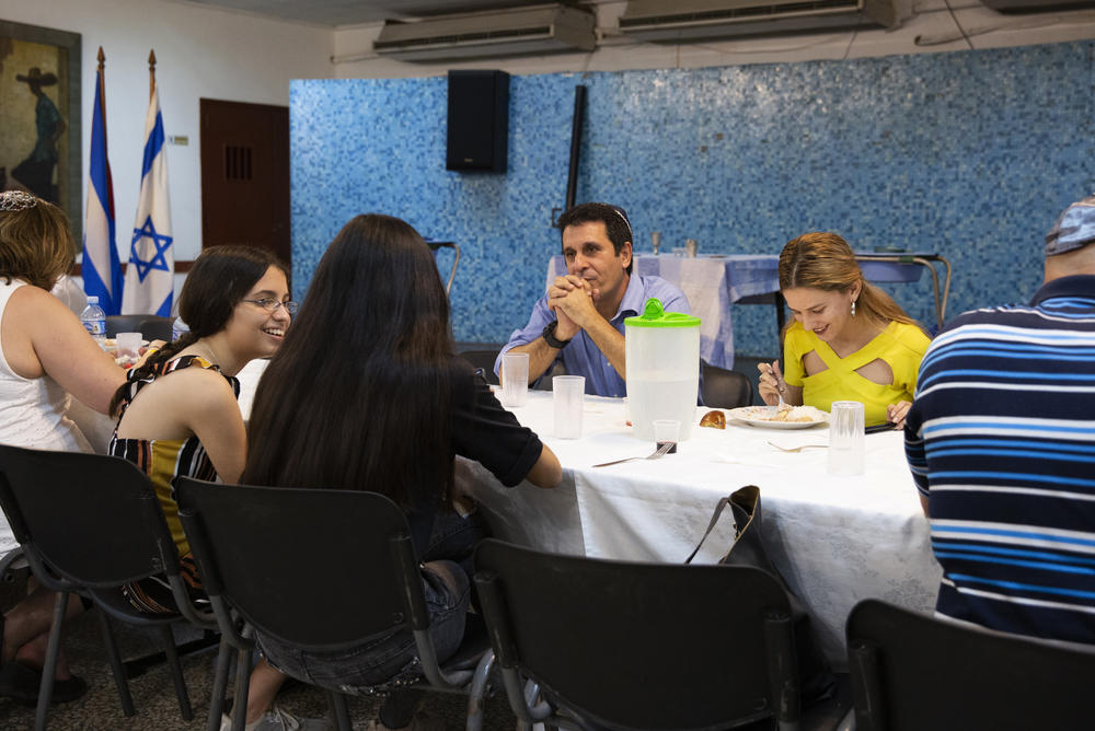 Adri Quiñones (in yellow) eats Shabbat dinner with her father, Isac (center), at Beth Shalom on Jan. 17, 2020.