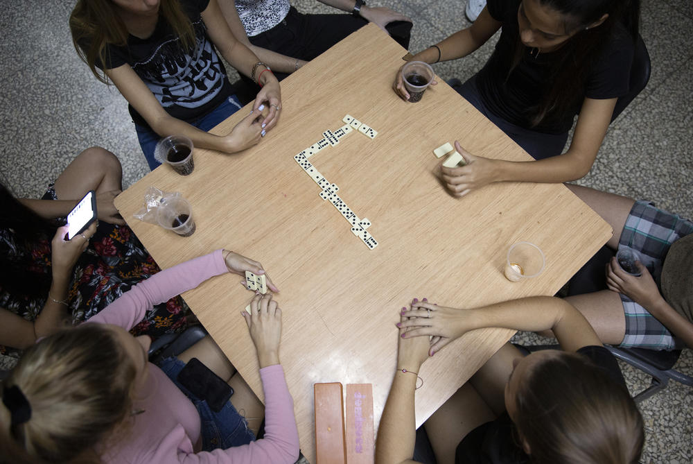 Adri, left, plays dominoes with the other members of Beth Shalom's youth group in the basement of the temple on Jan. 18, 2020.