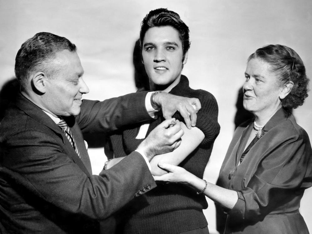Elvis Presley got his polio vaccination from Dr. Harold Fuerst and Dr. Leona Baumgartner at CBS' Studio 50 in New York City on Oct. 28, 1956. The chart-topping singer took part in a March of Dimes campaign to convince teens to get vaccinated.