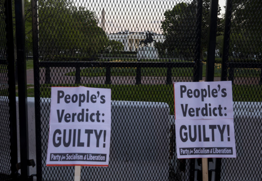 Signs lean against a fence in front of the White House in Washington, D.C.