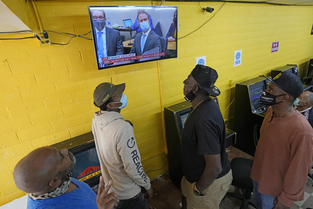People gather inside a convenience store in the Houston neighborhood where George Floyd grew up to listen to the verdict in the murder trial of Derek Chauvin.