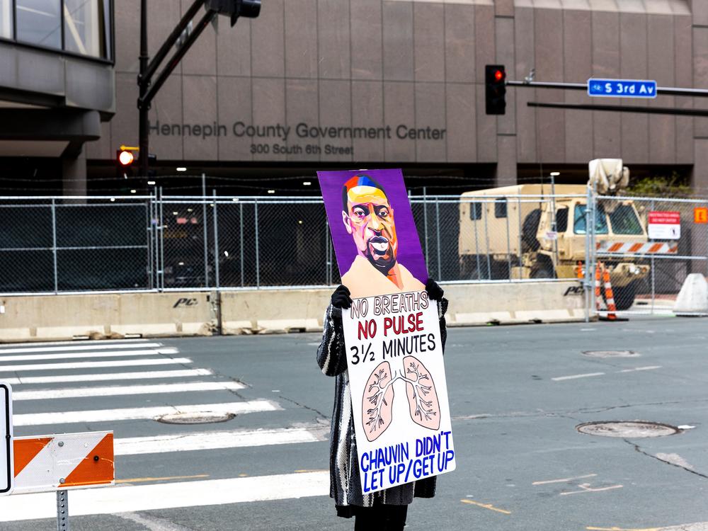 A lone protester stands outside the Hennepin County Courthouse on Monday as lawyers presented closing arguments in the murder trial of Derek Chauvin. The jury is now deliberating.