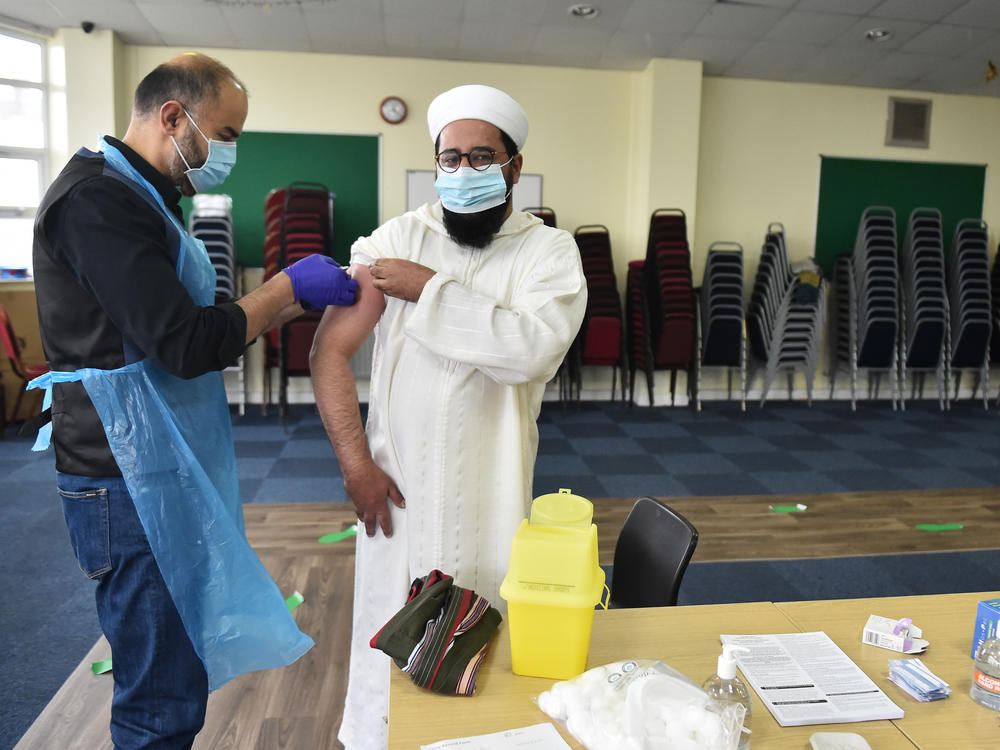 Mohammed Amir, the imam of the Stoke's City Central Mosque, receives a COVID-19 vaccination in February in Stoke, England. Imams across the United Kingdom are reassuring Muslims that the COVID-19 vaccine is permissible under Muslim law, as disinformation and mistrust of the authorities led to a lower acceptance rate among British Muslims.