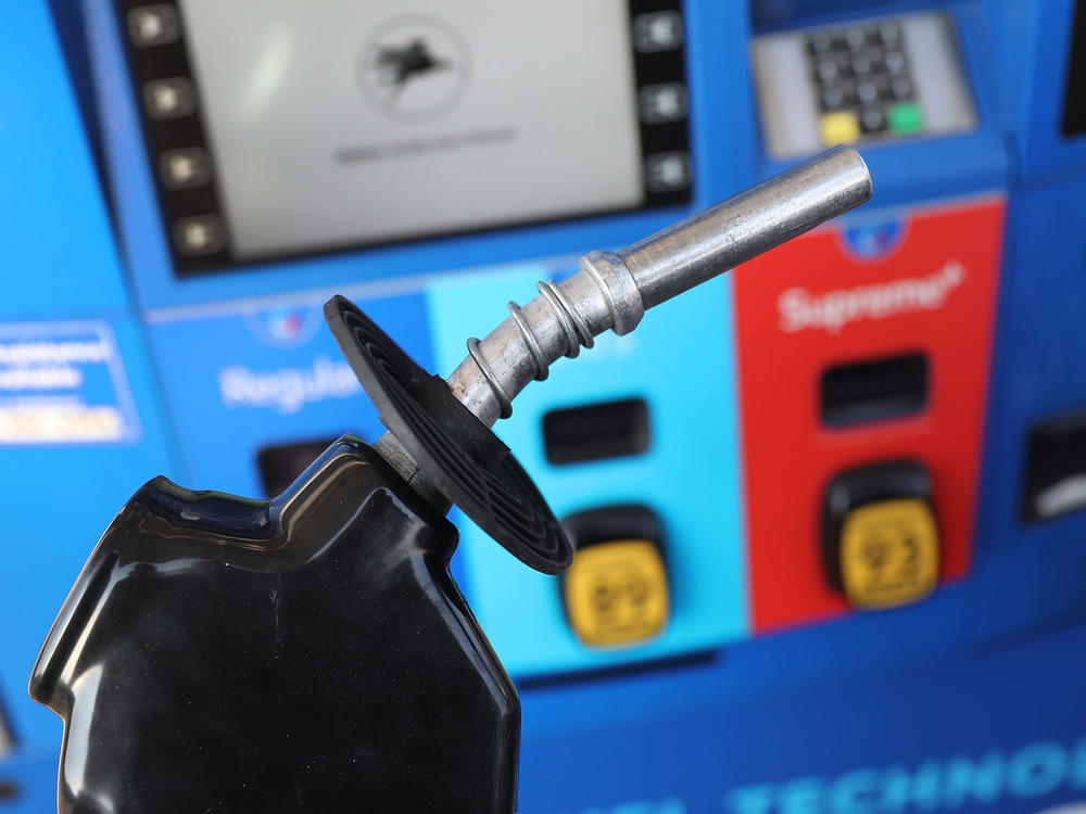 A gas pump nozzle is seen at a Miami gas station in 2018. Some activist shareholders are pushing companies to tie executive compensation to meeting climate targets.