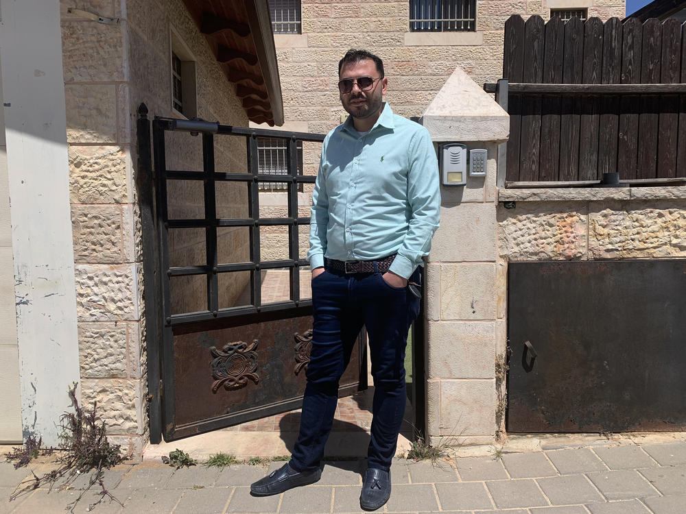Yehuda Ben Sheetrit, an ultra-Orthodox Jewish Israeli, lost his wife, Osnat, to COVID-19. He stands outside the new apartment he has moved into with his four children after losing his wife.