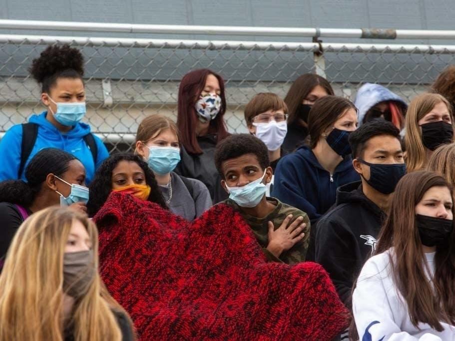 Students talk to each other during a walkout at Tartan High School in Oakdale, Minn., Monday.