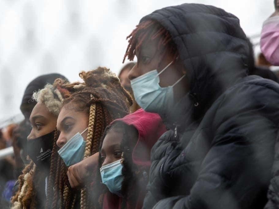 Students hold each other and listen to speakers during a walkout at Tartan High School in Oakdale, Minn., Monday.