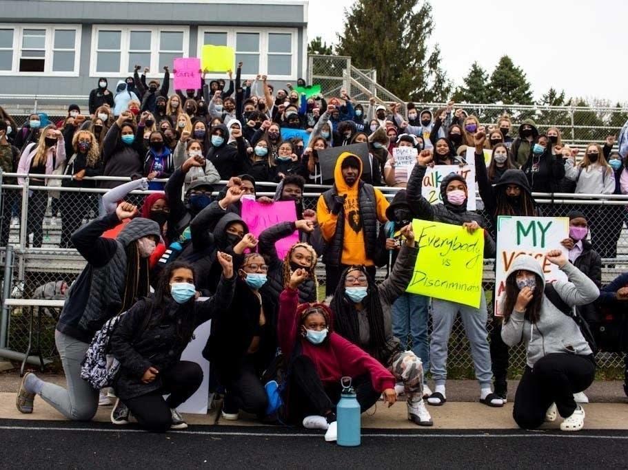 Students pose for photos during a walkout at Tartan High School in Oakdale, Minn.