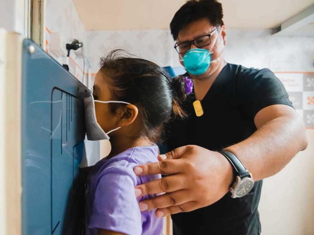 A young girl waits as her chest X-ray is taken in a TB Móvil van clinic in Lima, Peru.