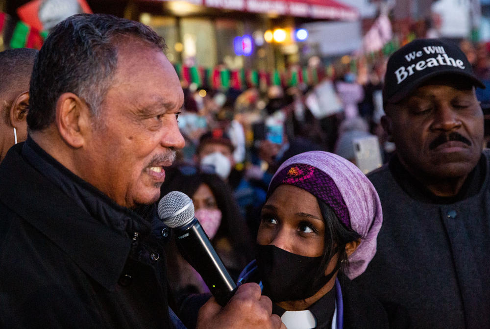 Rev. Jesse Jackson addresses the crowd at George Floyd Square as Jeanette Rupert and Spike Moss listen as people gather at the square.