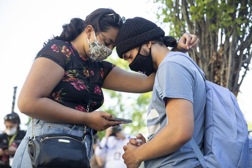 Joseph Ravago and Kamaile Elderts of California wait for the verdict at Black Lives Matter  Plaza in Washington, D.C.