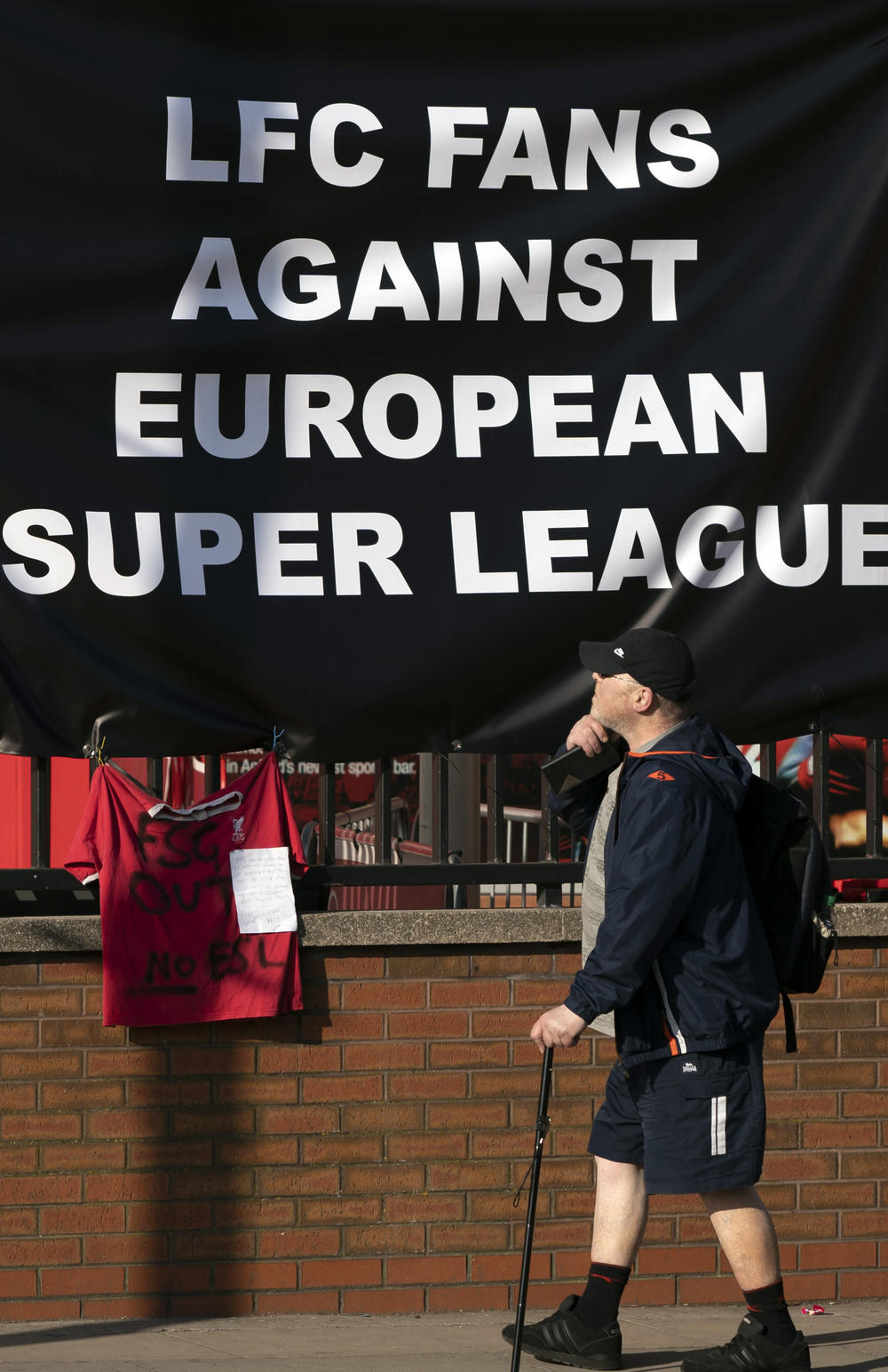 A member of the public passes a banner outside Liverpool's Anfield Stadium protesting the formation of the European Super League.