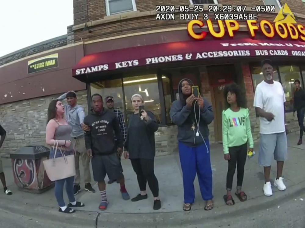 An image from a police body camera shows bystanders outside Cup Foods in Minneapolis on May 25, 2020. The group includes Darnella Frazier, third from right, as she made a 10-minute recording of George Floyd's death.