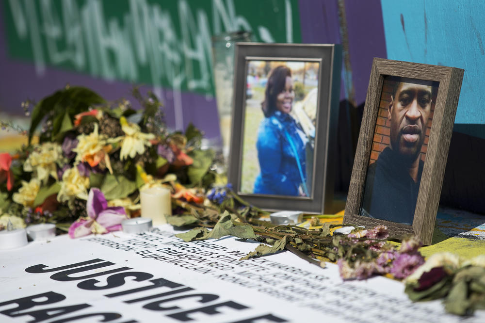 Photographs of Breonna Taylor, and George Floyd, right, are shown included in a vigil that remains near the intersection of 11th Avenue and East Pine Street on in Seattle. 'Justice For All Victims of Racist Police Terror' read the words, surrounded by candles and flowers as well as photographs of those unjustly killed by police.