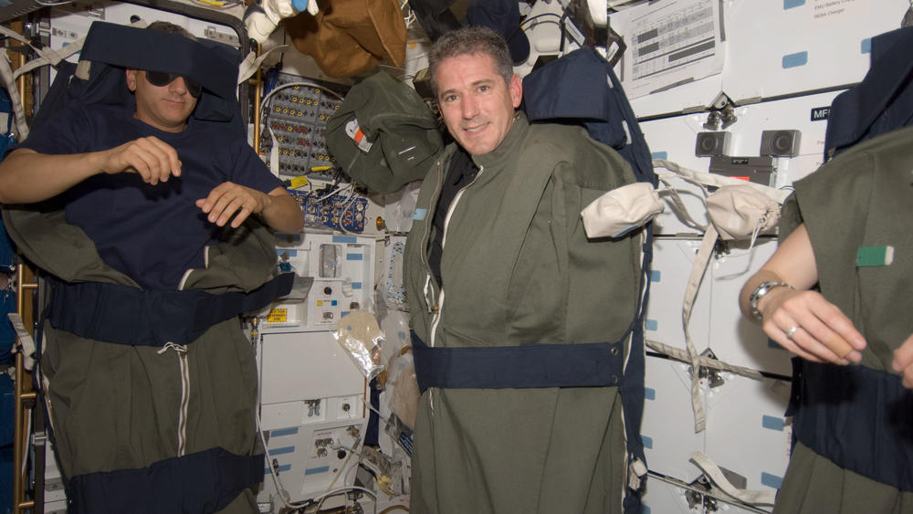Astronauts Mike Massimino (left) and Michael Good are pictured in their sleeping bags, which are attached to the lockers of the Earth-orbiting space shuttle Atlantis in 2009.