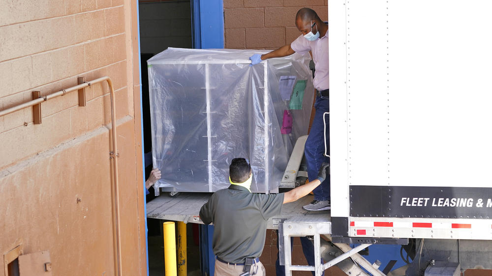 Officials on Wednesday unload election equipment into the Veterans Memorial Coliseum in Phoenix for a controversial audit sought by state Republicans.