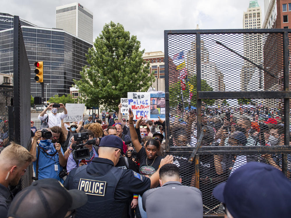 Protesters gather outside the entrance to a rally for then-President Donald Trump in June in Tulsa, Okla. A new state law increases penalties for protesters who block public roadways and grants legal immunity to drivers who unintentionally harm them as they try to flee.