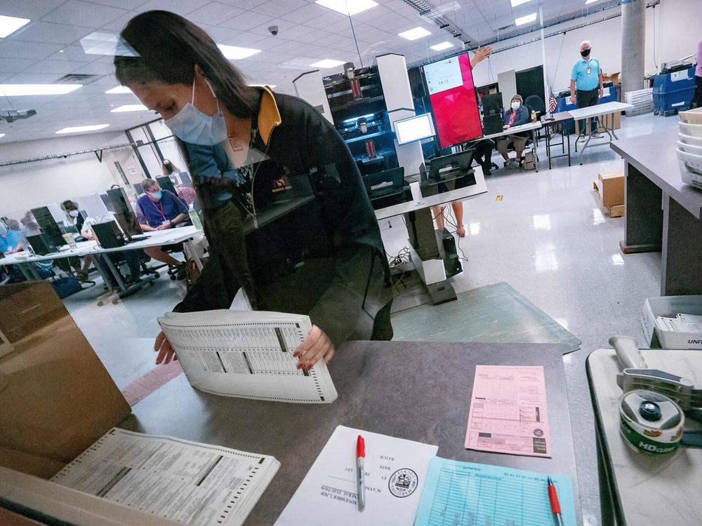 A poll worker sorts ballots inside the Maricopa County Election Department in Phoenix on Nov. 5, 2020. Republican voting bills in Arizona are on hold after a GOP state senator came out in opposition.