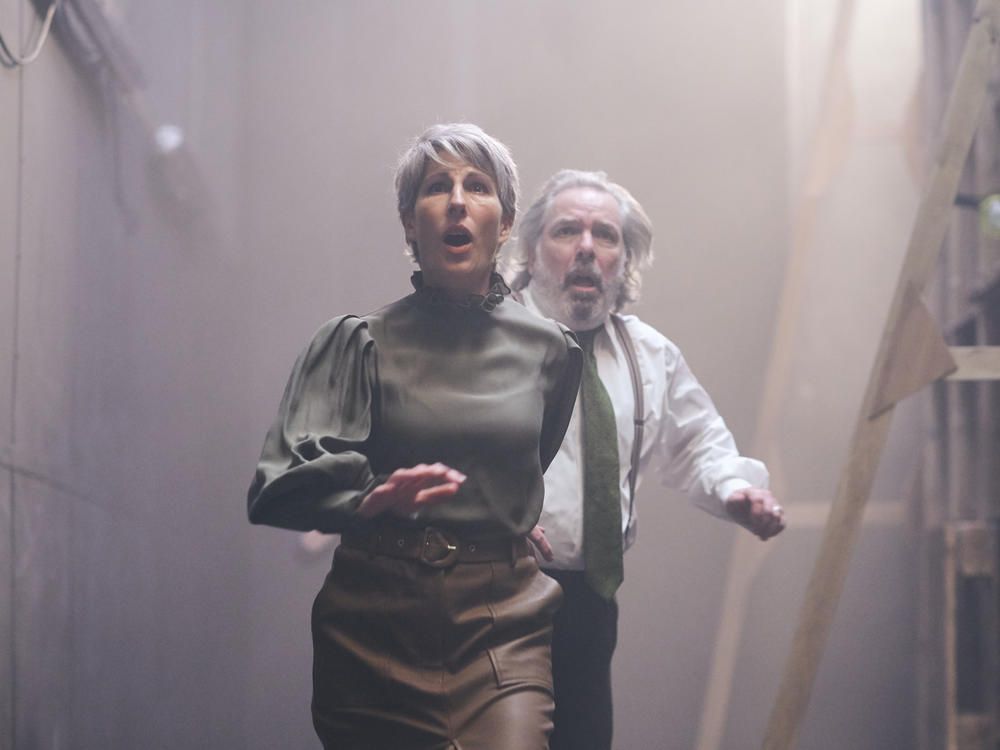 Tamsin Grieg and Lloyd Hutchinson as Lady Capulet and Lord Capulet, surrounded by the haunting open spaces of the Lyttleton Theatre.