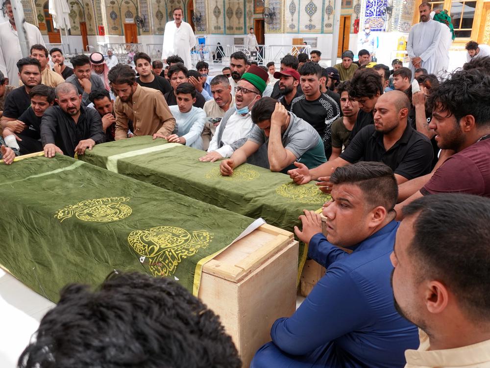 Iraqis in the holy shrine city of Najaf on Sunday mourn relatives killed during a massive fire at a Baghdad hospital dedicated to COVID-19 patients.