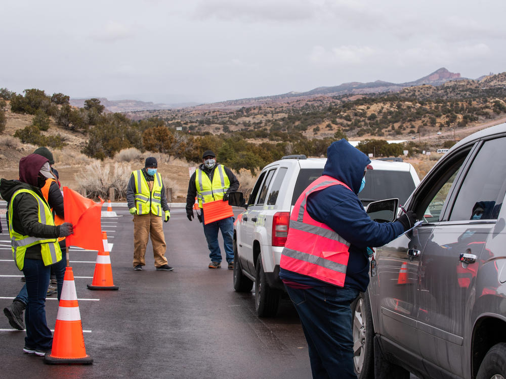Workers greet arrivals at a drive-in vaccination site at University of New Mexico's Gallup campus in Gallup, N.M., on March 23. The Navajo Nation has vaccinated more than half of its adult population, outpacing the U.S. national rate.