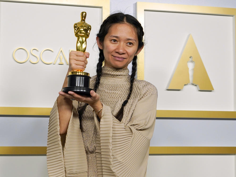 <a href="https://www.npr.org/sections/live-updates-oscars-2021/2021/04/25/988816124/chloe-zhao-is-the-first-woman-of-color-to-win-oscar-for-best-director">Chloé Zhao</a> poses in the press room at the Oscars on April 25, 2021, at Union Station in Los Angeles.
