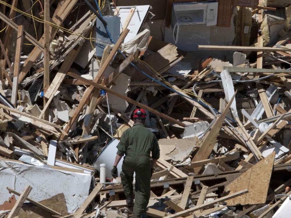 In this file photo taken May 4, 2011, Tuscaloosa Fire Lt. Brian Phillips climbs a pile of rubble in search of survivors or bodies at an apartment building in Tuscaloosa, Ala. On April 27, 2011, a series of tornadoes killed hundreds of people, injured thousands and reduced countless buildings to rubble across a swath of the U.S.