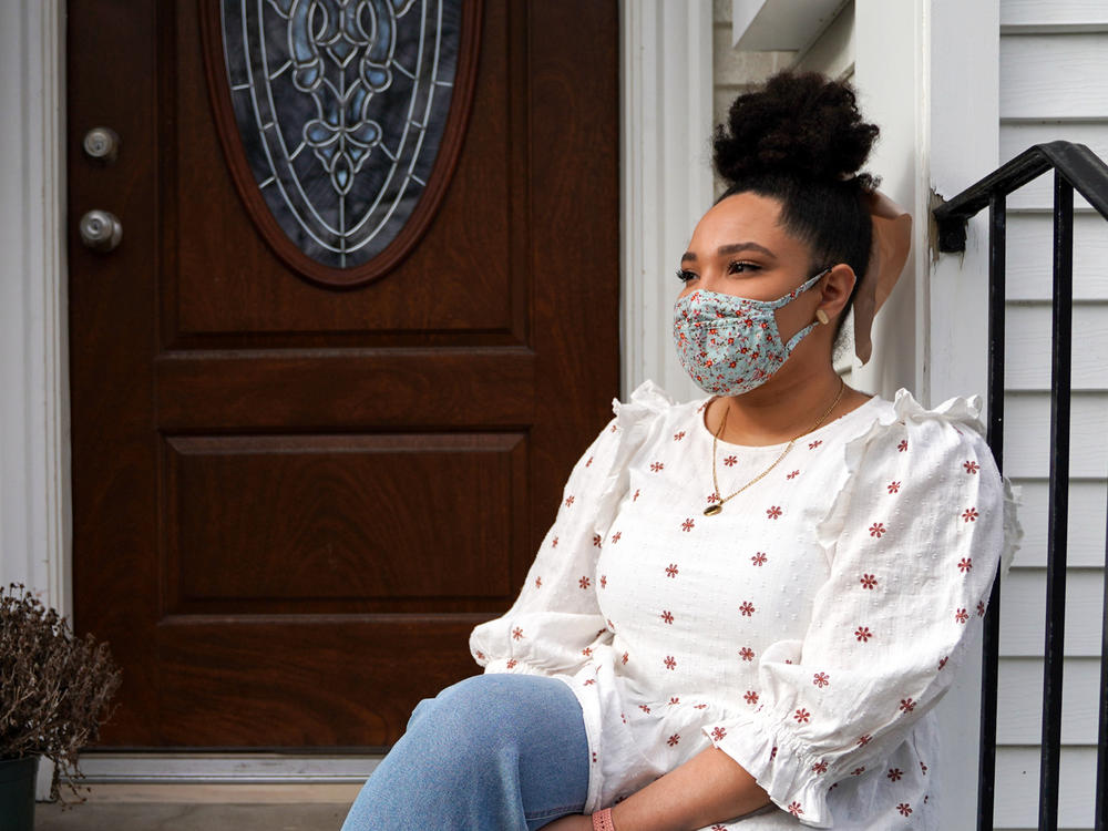 Emily Knowles sits outside her apartment in Watertown, Mass. Knowles has some college credits but no degree and works as a quality assurance analyst at Ovia Health, a Boston-based digital company that serves people who are starting families. 
