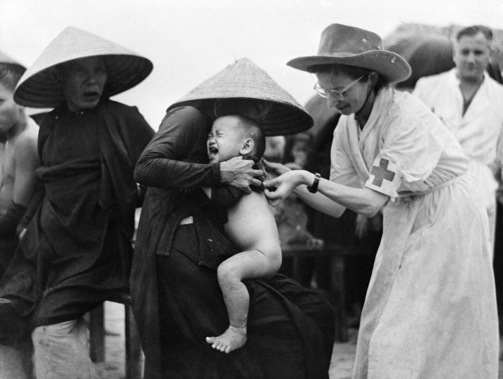 Marie Josette Francou (right), a Red Cross nurse, vaccinates a child against cholera in 1953 in Indochina (now Vietnam).